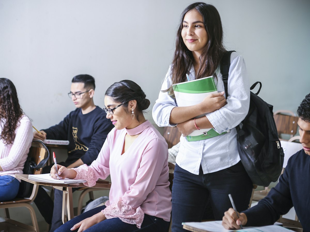 A student on their way to deliver a session, course materials in hand.